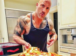 The Rok presentando una bandeja de pizza hawaiana con piña y jamón, lista para hornear.